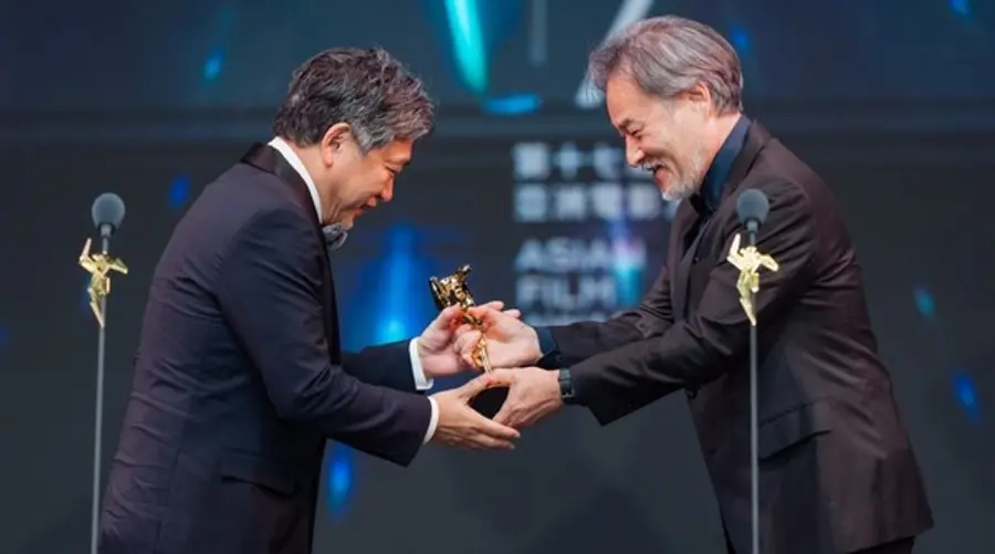 감독상을 받은 고레에다 히로카즈 감독과 트로피를 건네는 구로사와 기요시 감독(사진 오른쪽)