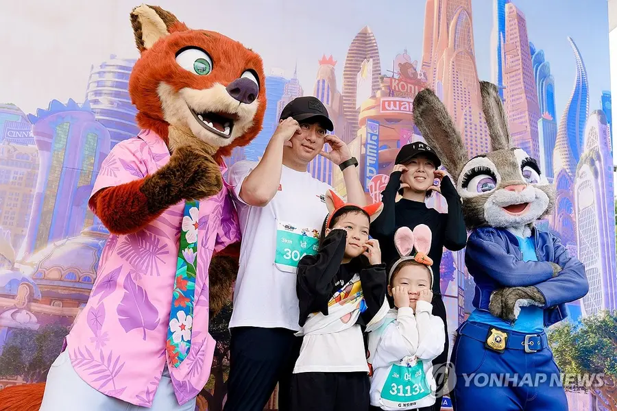 At the 'Disney Run Seoul 2025' event held at Yeouido Park in Seoul, characters 'Nick' and 'Judy' from the animation 'Zootopia' pose for a commemorative photo with family participants [Yonhap News]