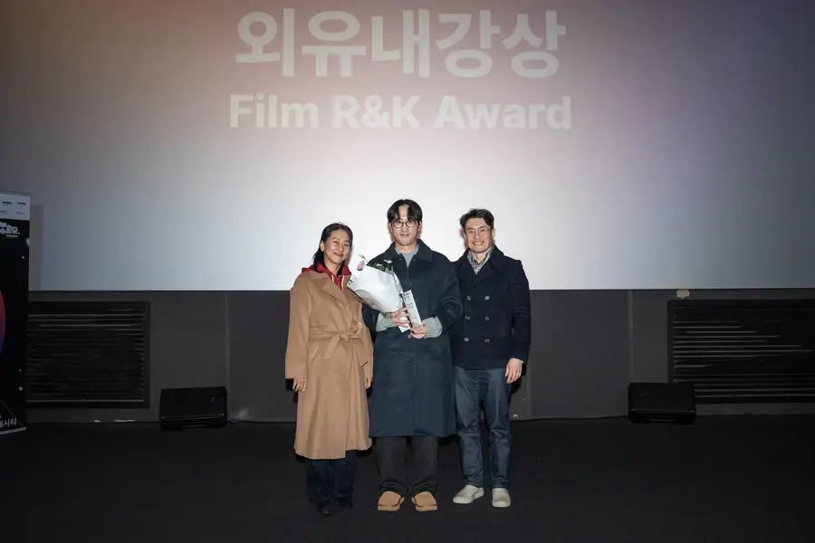 ソウル独立映画祭2025『外柔内剛賞』受賞者チョ・バルン監督が外柔内剛カン・ヘジョン代表（左端）とリュ・スンワン監督（右端）と記念写真を撮っている。