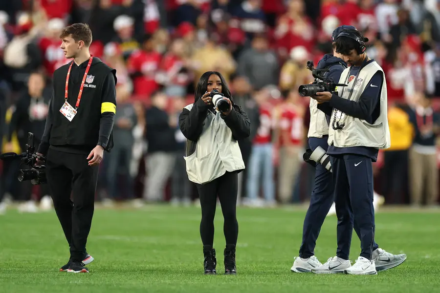 SANTA CLARA, CALIFORNIA - DECEMBER 28: Vận động viên thể dục Simone Biles chụp ảnh trên sân trước trận đấu giữa San Francisco 49ers và Chicago Bears tại Sân vận động Levi's vào ngày 28 tháng 12 năm 2025 tại Santa Clara, California. Ezra Shaw/Getty Images/AFP