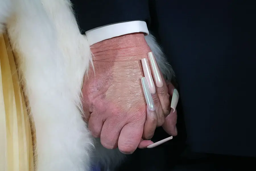 Musician Nicki Minaj (L) and U.S. President Donald Trump hold hands on stage during the Treasury Department's Trump Accounts Summit at Andrew W. Mellon Auditorium on January 28, 2026 in Washington, DC. "Trump Accounts" are a portion of recently passed tax and spending legislation where the federal government will deposit $1,000 into investment accounts for every child born between 2025 and 2028 once parents sign their children up while filing their income taxes. Win McNamee/Getty Images/AFP