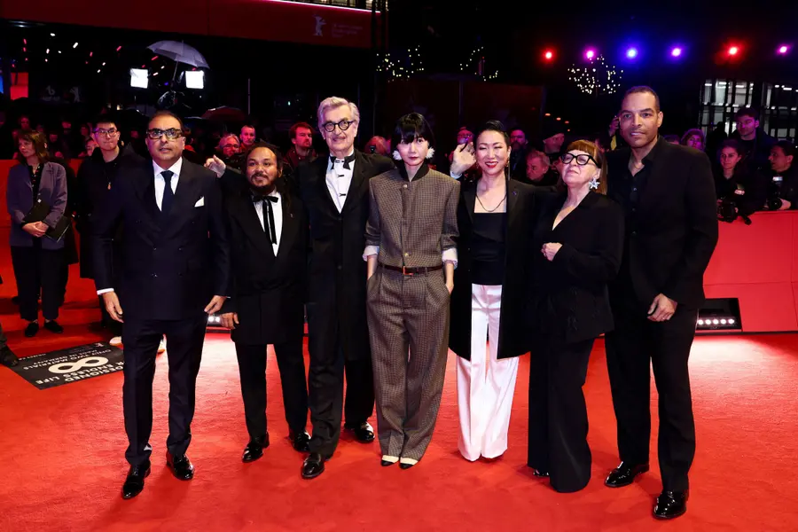 At the premiere red carpet event for the opening film 'No Good Men', jury chair Wim Wenders and jury members including Bae Doona pose for photos. /REUTERS