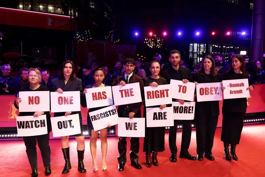 Some guests are protesting on the red carpet holding placards. /REUTERS